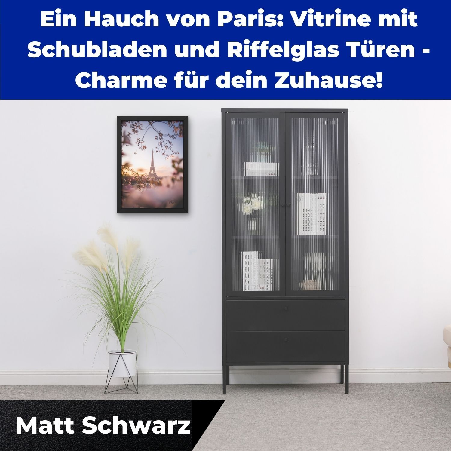 Vitrine Paris Schwarz im Zimmer. Daneben eine Zimmerpflanze. Ein Wandbild hängt.