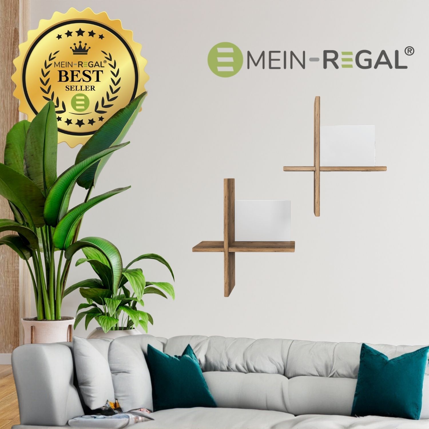 Wandregal Brick Natur/Weiß hängend an hellgrauer Wand über einem grauen Sofa mit grauen und petrolfarbenen Sofakissen. Links stehen zwei Zimmerpflanzen. Oben drüber steht das Logo Mein-Regal.