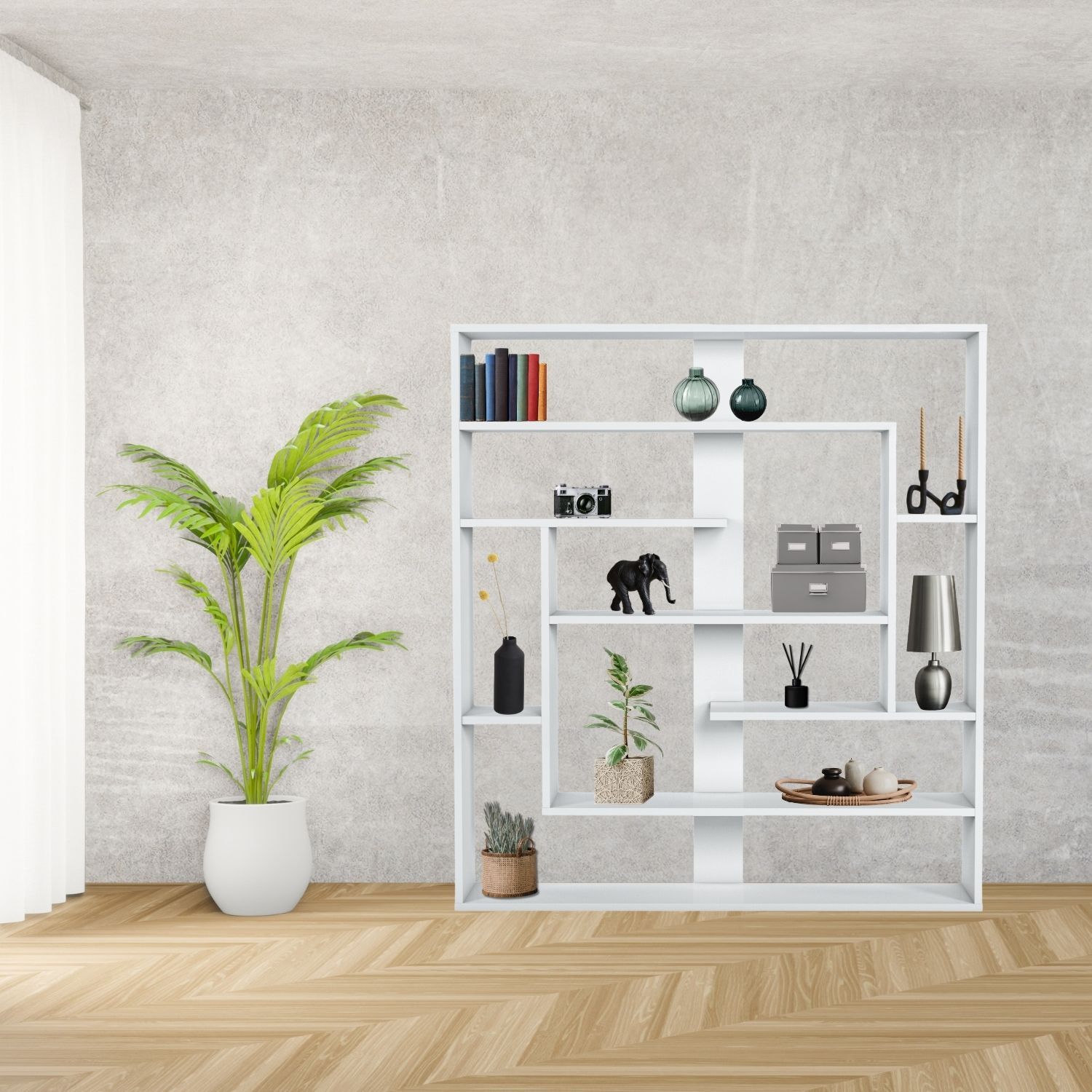 Wandregal Sebastian Weiß im Zimmer an grauer Wand stehend neben einer Zimmerpflanze. Im Regal stehen Bücher, Vasen, Kerzen, Leuchter, Pflanzen, Boxen, Fotoapparat.