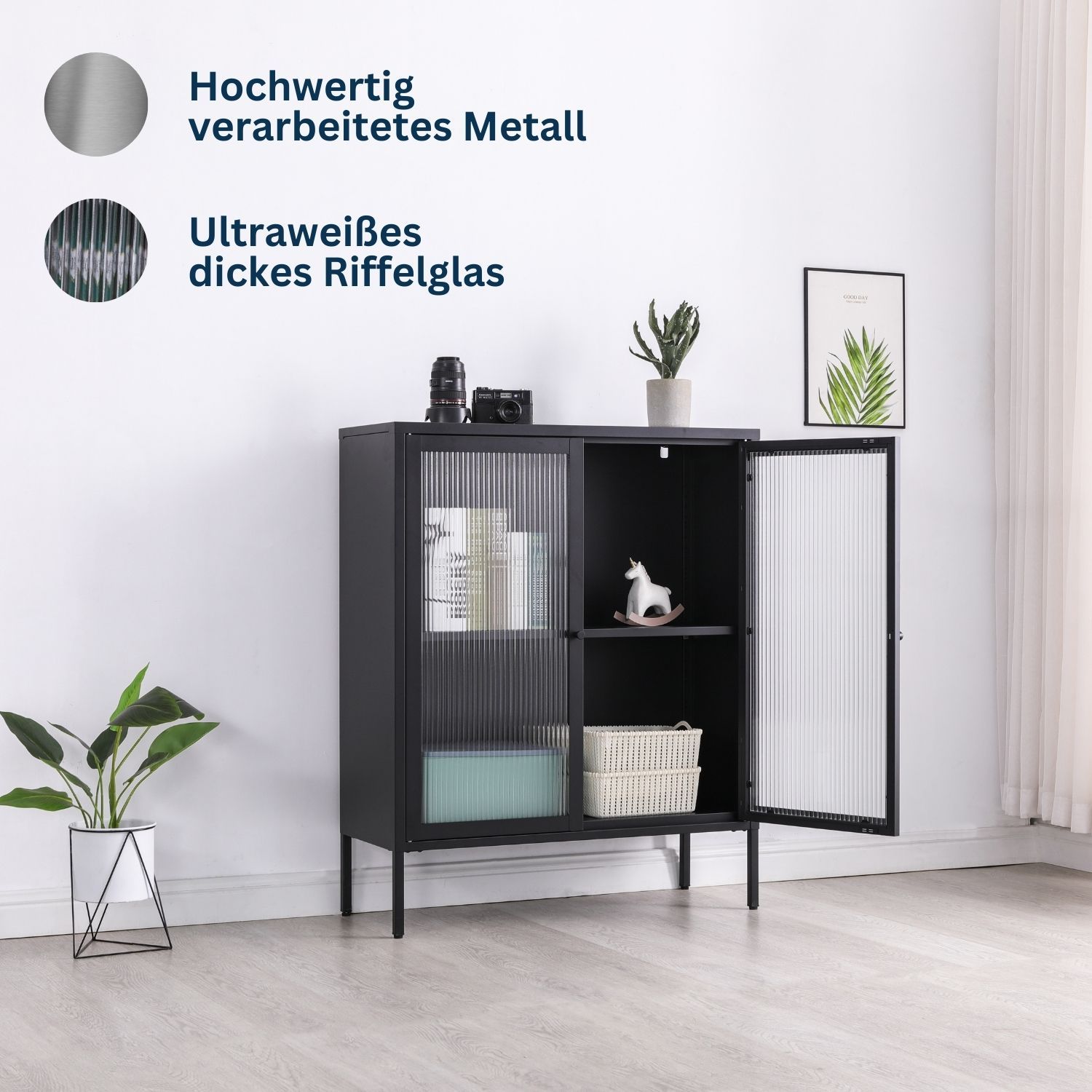 Highboard Schwarz Tokio Metall im Zimmer mit geöffneter Tür. Links daneben steht eine Zimmerpflanze. Rechts hängt ein Wandbild