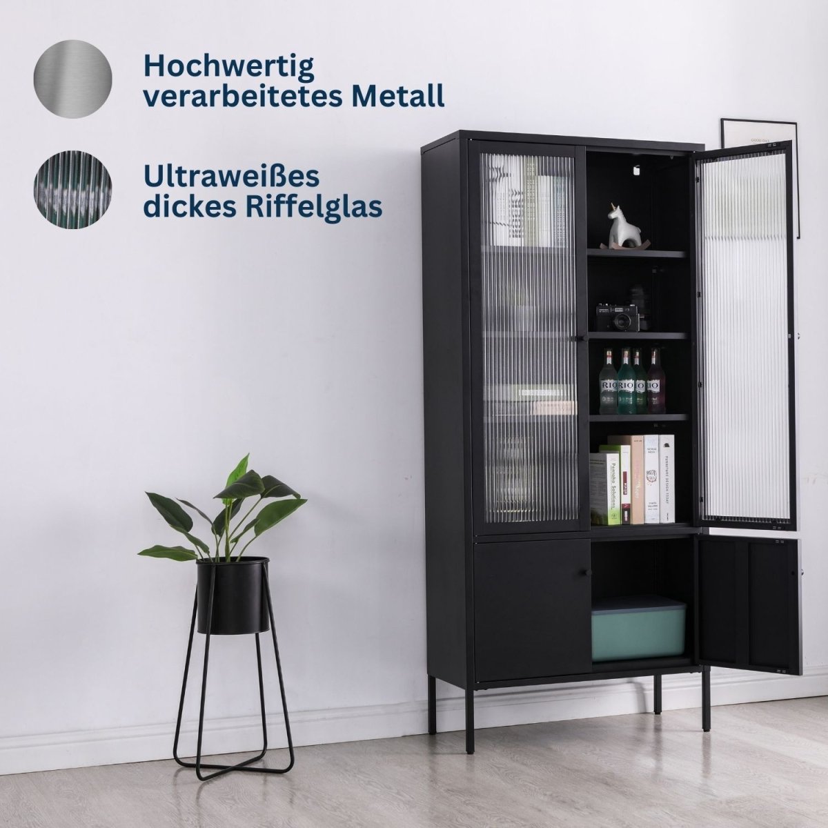 Vitrine Tokio Schwarz aus Metall in einem Zimmer. Oben und unten ist eine Tür geöffnet und zeigt den Inhalt. Daneben steht eine Zimmerpflanze.