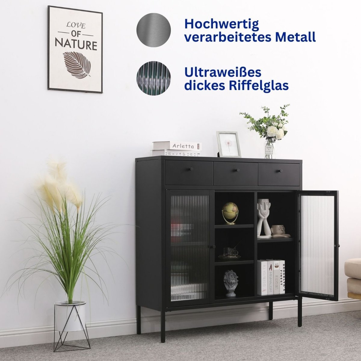 Kommode Paris Schwarz aus Metall in einem Zimmer. Eine Tür ist geöffnet und zeigt den Inhalt. Daneben steht eine Zimmerpflanze. Ein Wandbild hängt.