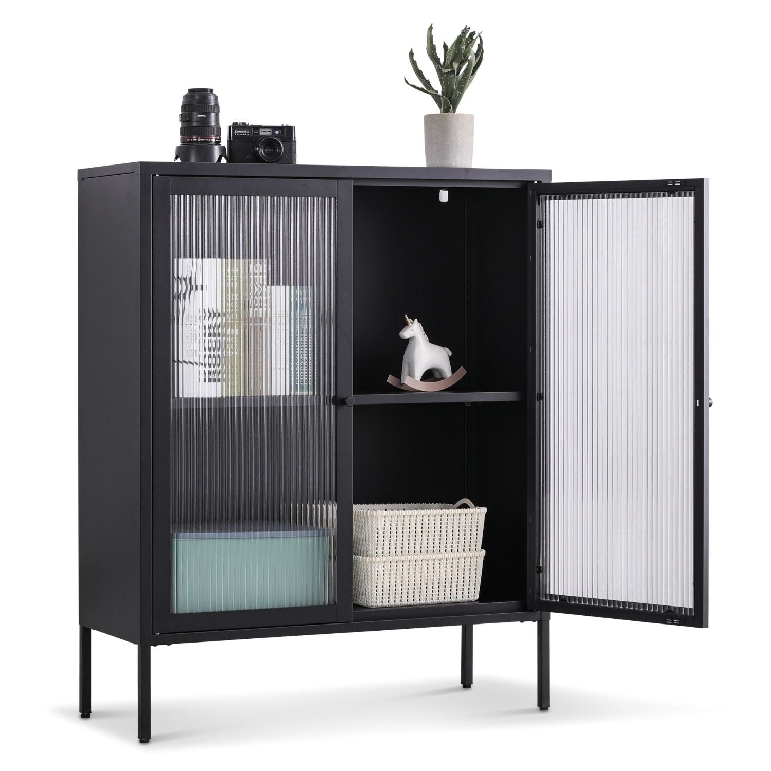 Highboard Tokio Metall in Schwarz mit geöffneter rechten Tür. Innen stehen zwei Körbe und ein Dekoschaukelpferd. Auf der Oberfläche ist eine Fotokamera und eine Zimmerpflanze