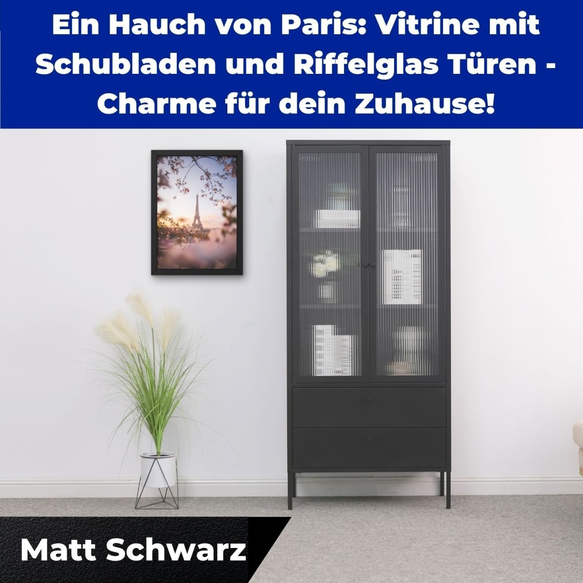 Vitrine Paris Schwarz im Zimmer. Daneben eine Zimmerpflanze. Ein Wandbild hängt.